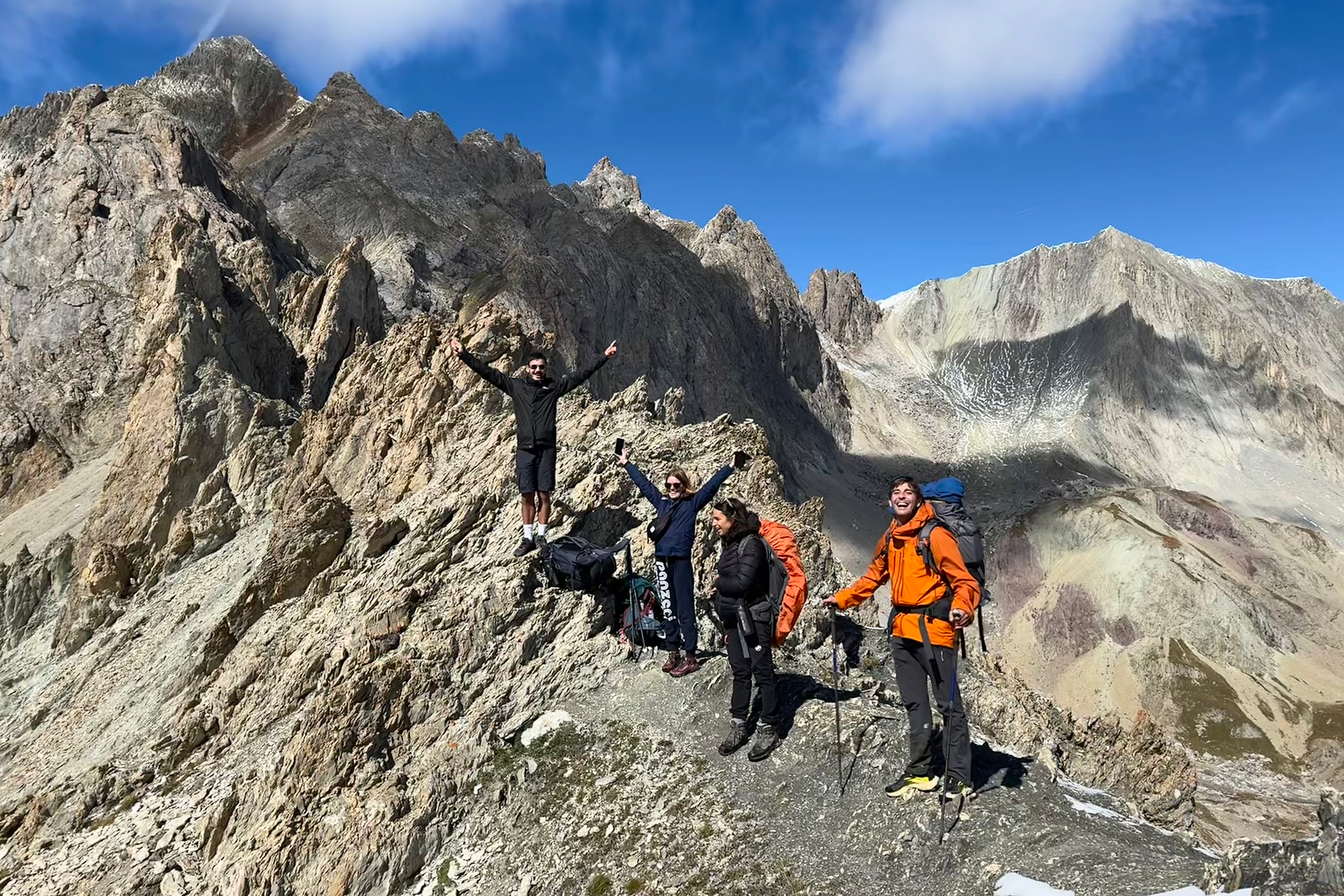 Les copains randonneurs posent au sommet du col des Béraudes entourés par l'immensité de la montagne