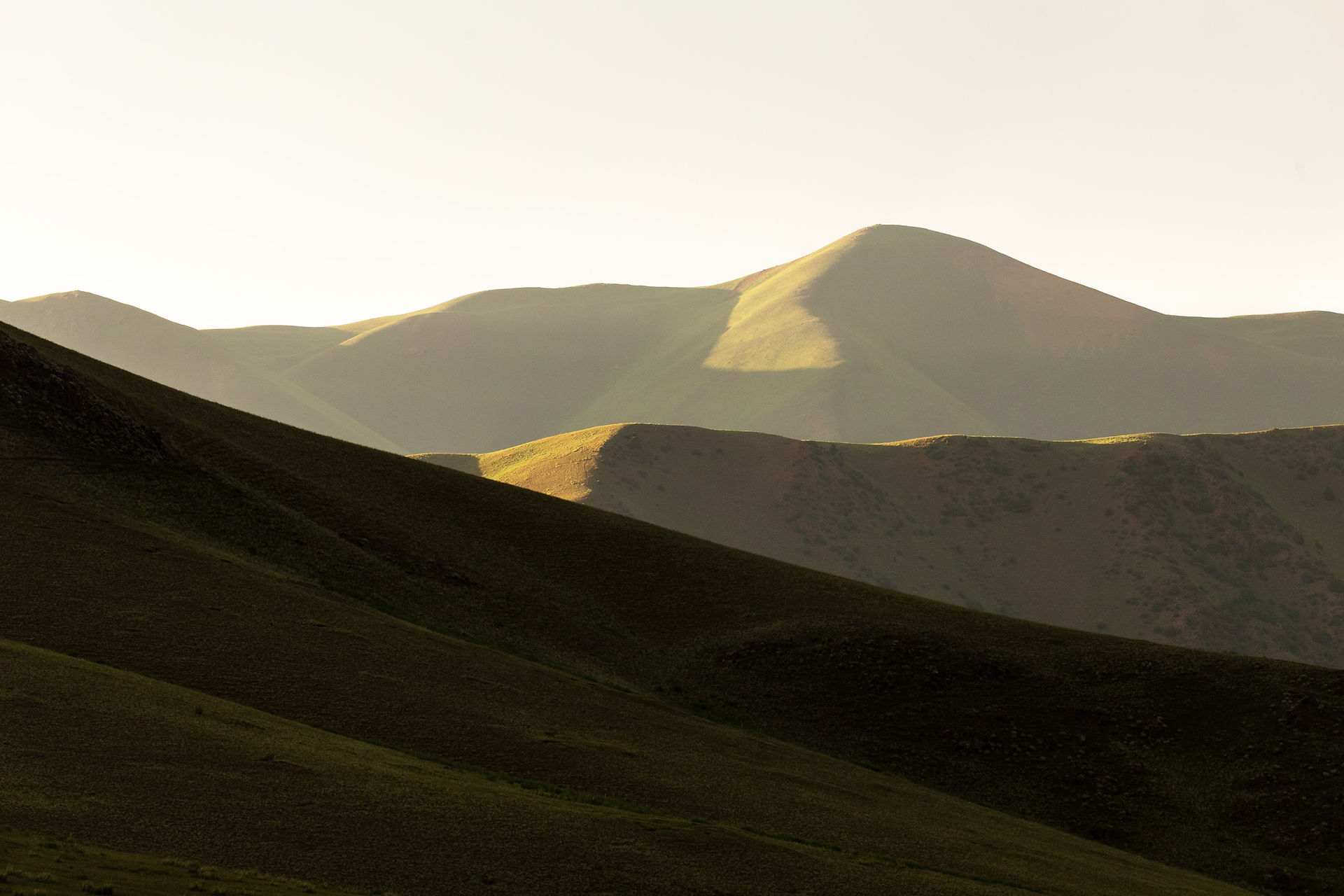 Différentes teintes de vert se succèdent dans ce panorama où s'empilent les montagnes dans une belle perspective.