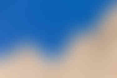 Un vautour plane au-dessus de falaises rocheuses sous un ciel bleu dégagé, capturant un moment de sérénité en altitude
