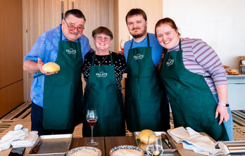 Family smiling holding pasta at HALL Park Hotel in Frisco, Texas.