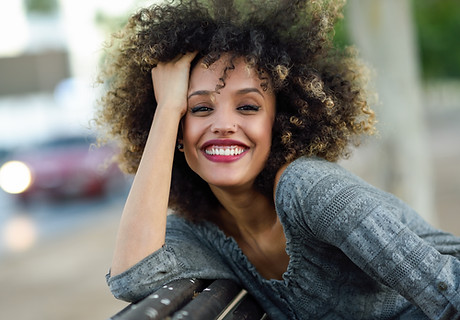 Mulher de sorriso com cabelo encaracolado