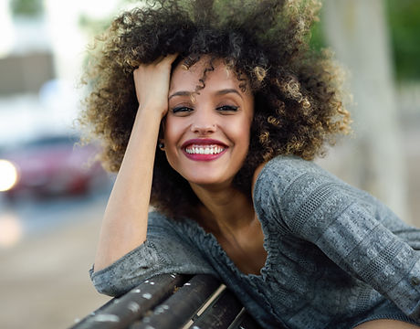 Mulher de sorriso com cabelo encaracolado