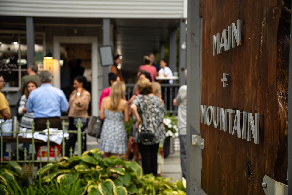 The exterior sign of the building with people at a private event in the background