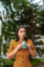girl drinking a blue mocktail outside on the patio