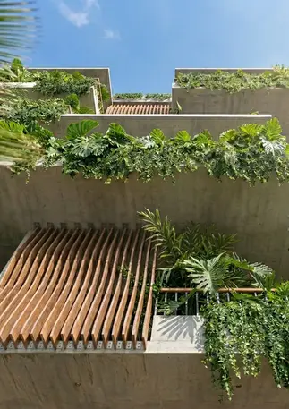 Detalle de balcones con planos seriados de madera y vegetación colgante en fachada bioclimática.