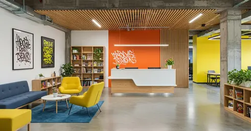 Recepción moderna y zona de espera lounge con techo de listones de madera y colores corporativos para oficinas en Cali.
