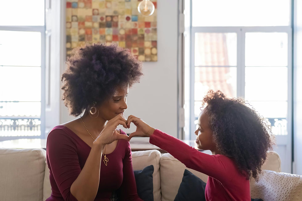 Photo d'une maman et sas fille faisant un cœur avec leurs mains