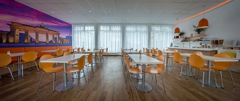 Bright hotel dining area with tables, chairs and large windows