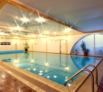 Indoor swimming pool with warm lighting and mountain mural