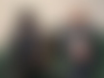 Deux collaborateurs en tenue professionnelle discutant assis sur un canapé dans un espace de bureau.