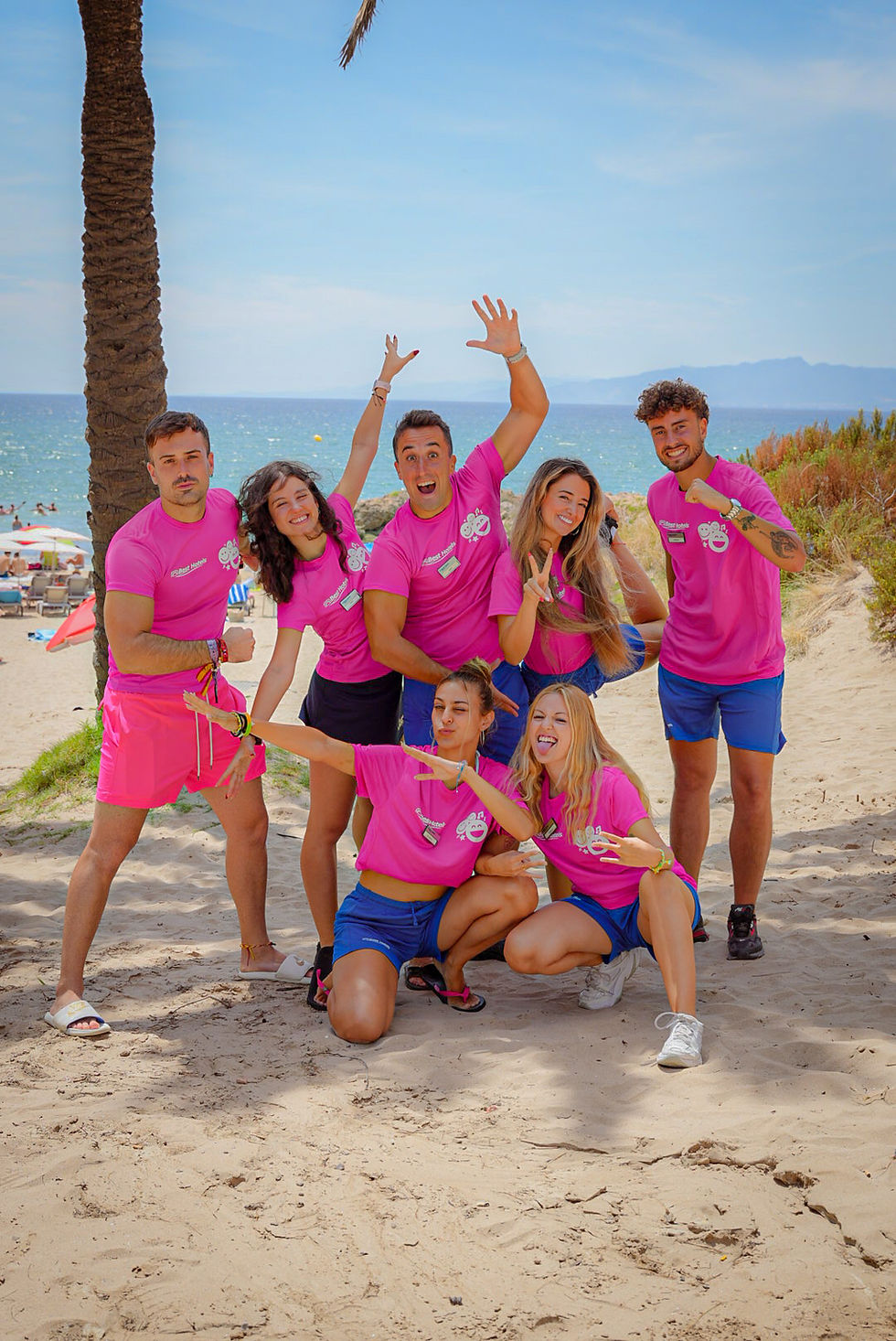 Agencia de animadores y shows posando alegres en la playa.