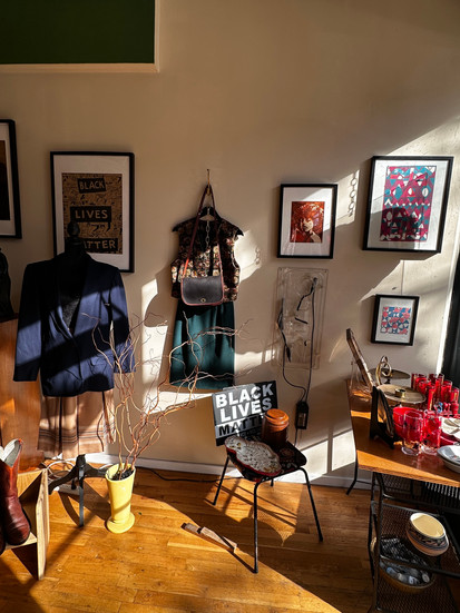 an assortment of clothing items with pictures hanging on a storefront