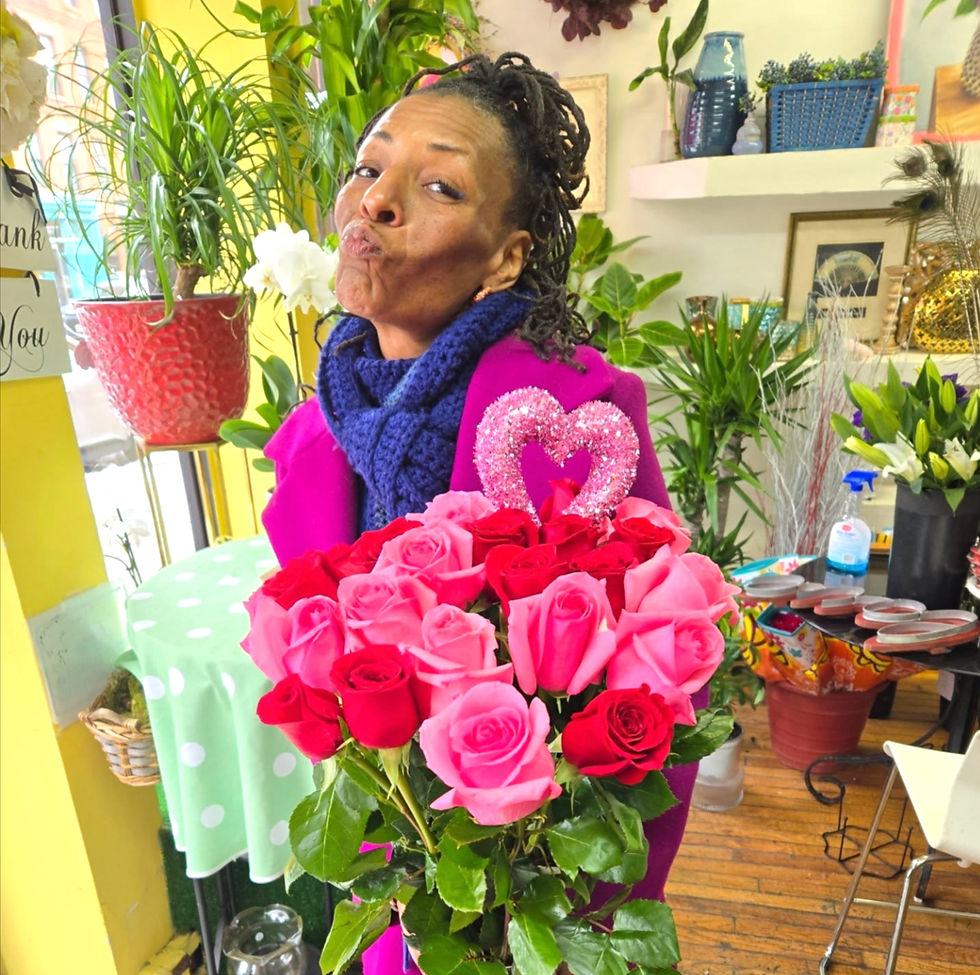 Person holding a vibrant bouquet of flowers with mixed blooms, including roses, lilies, and daisies