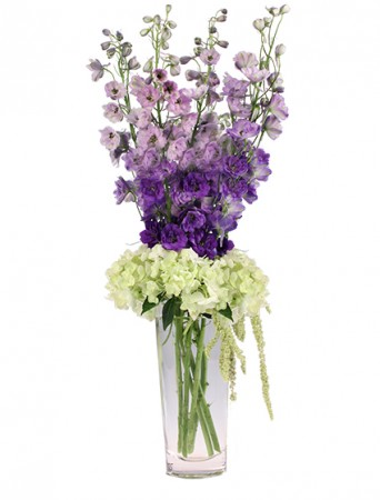 Person holding a vibrant bouquet of flowers with mixed blooms, including roses, lilies, and daisies