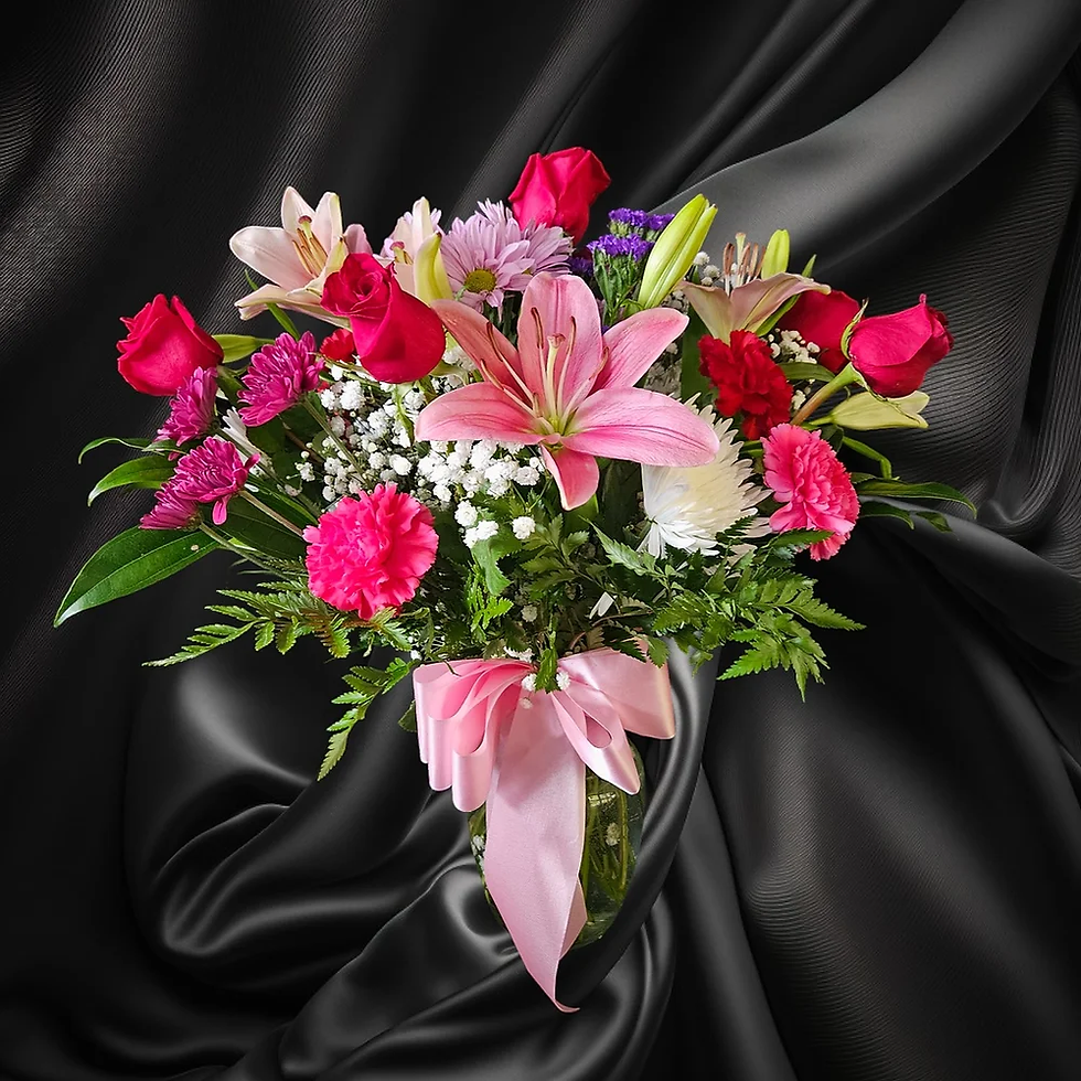 Person holding a vibrant bouquet of flowers with mixed blooms, including roses, lilies, and daisies