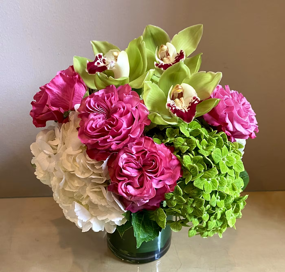 Person holding a vibrant bouquet of flowers with mixed blooms, including roses, lilies, and daisies