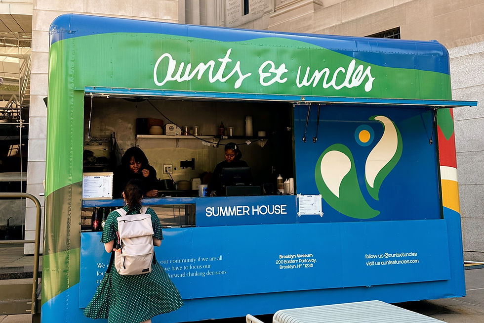 Blue and green food truck with "Aunts et uncles" sign. Two women inside serving a customer. Text: "Summer House," "Brooklyn Museum."