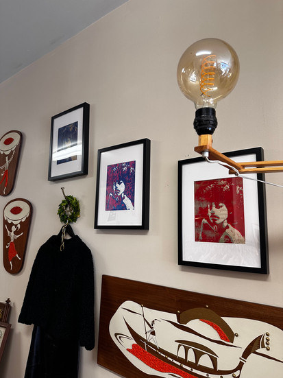 colorful pictures of a girl with an afro hanging on a storefront wall