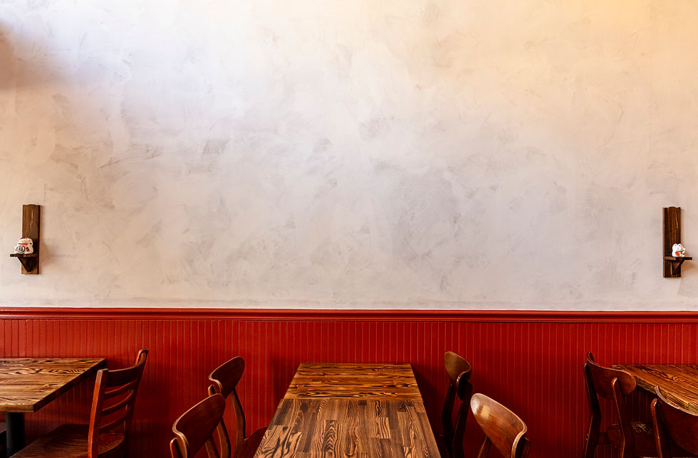 Photo of the interior wall of Good Luck Gato showing a few tables and chairs