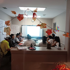 Profesora explicando una lección a estudiantes de nivel básico