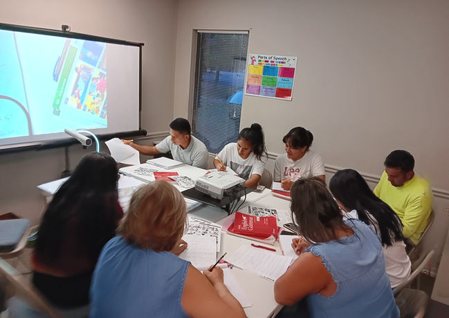 Alumnos tomando apuntes durante una lección de gramática.