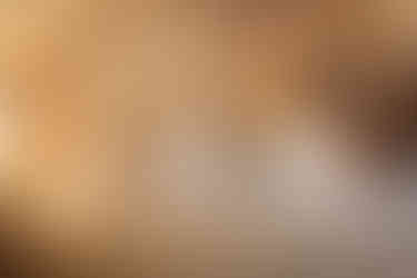 Double bed with green bedspread and floral cushions