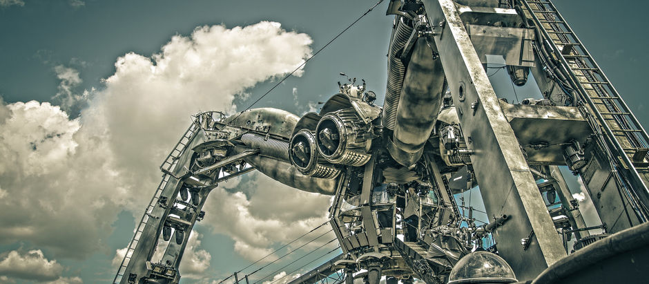 Futuristic, metallic structure with large engines set against a cloudy sky. No visible text. Industrial and surreal atmosphere.