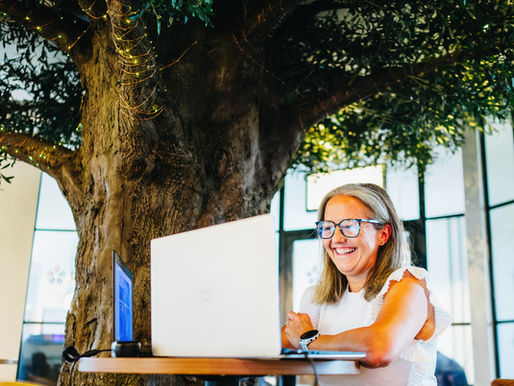 Jo is sat smiling at a laptop, clearly engaged in an online conversation