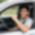 A young adult is leaning out of a car window, smiling.