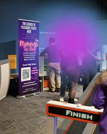 Vibrator race activity beside Mommys Toy Shop banner at Dark Matters Edmonton