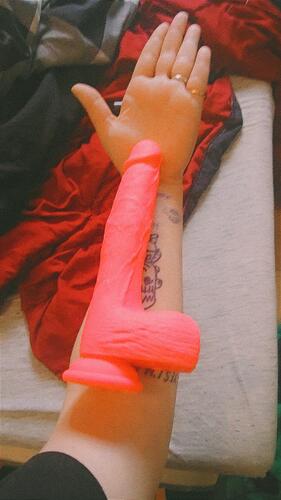 the thrusting pink dildo in a womans forearm showing size