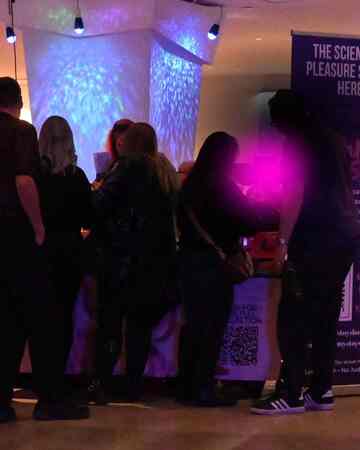 Mommys Toy Shop booth at Dark Matters event in Edmonton with science-themed pleasure banner and crowd