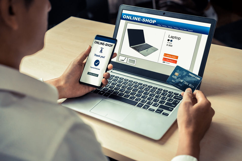 Una persona frente a su computadora, en la pantalla se muestra que está haciendo una compra en línea. Con su mano derecha sostiene su tarjeta de crédito.