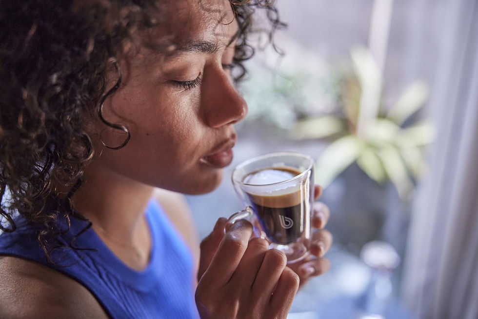 Mujer disfrutando de un café espresso.