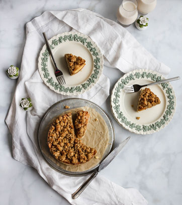 Fall food photography of an apple topped cheesecake with a cardamon cookie crust.