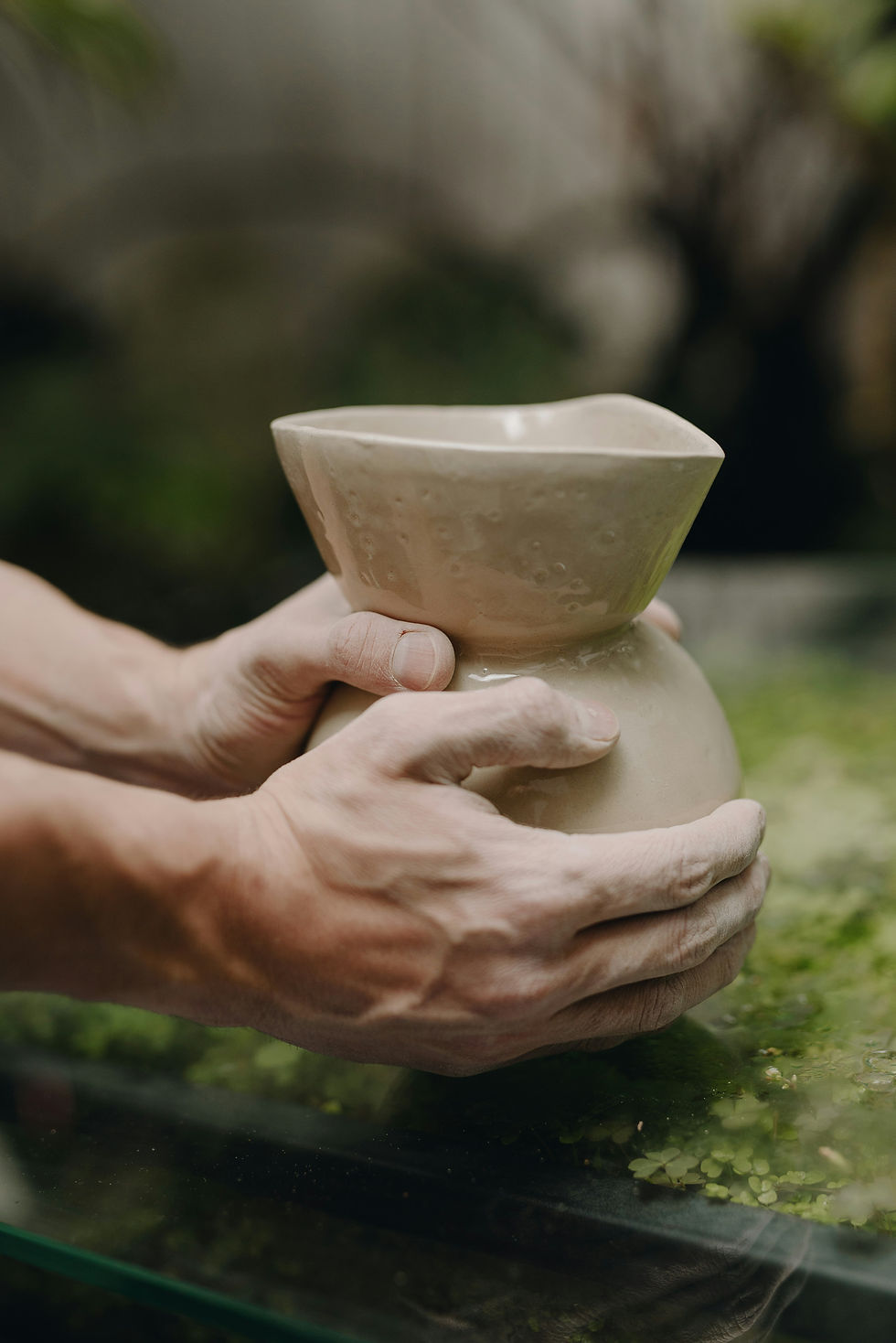 an artisan is building a pottery vase