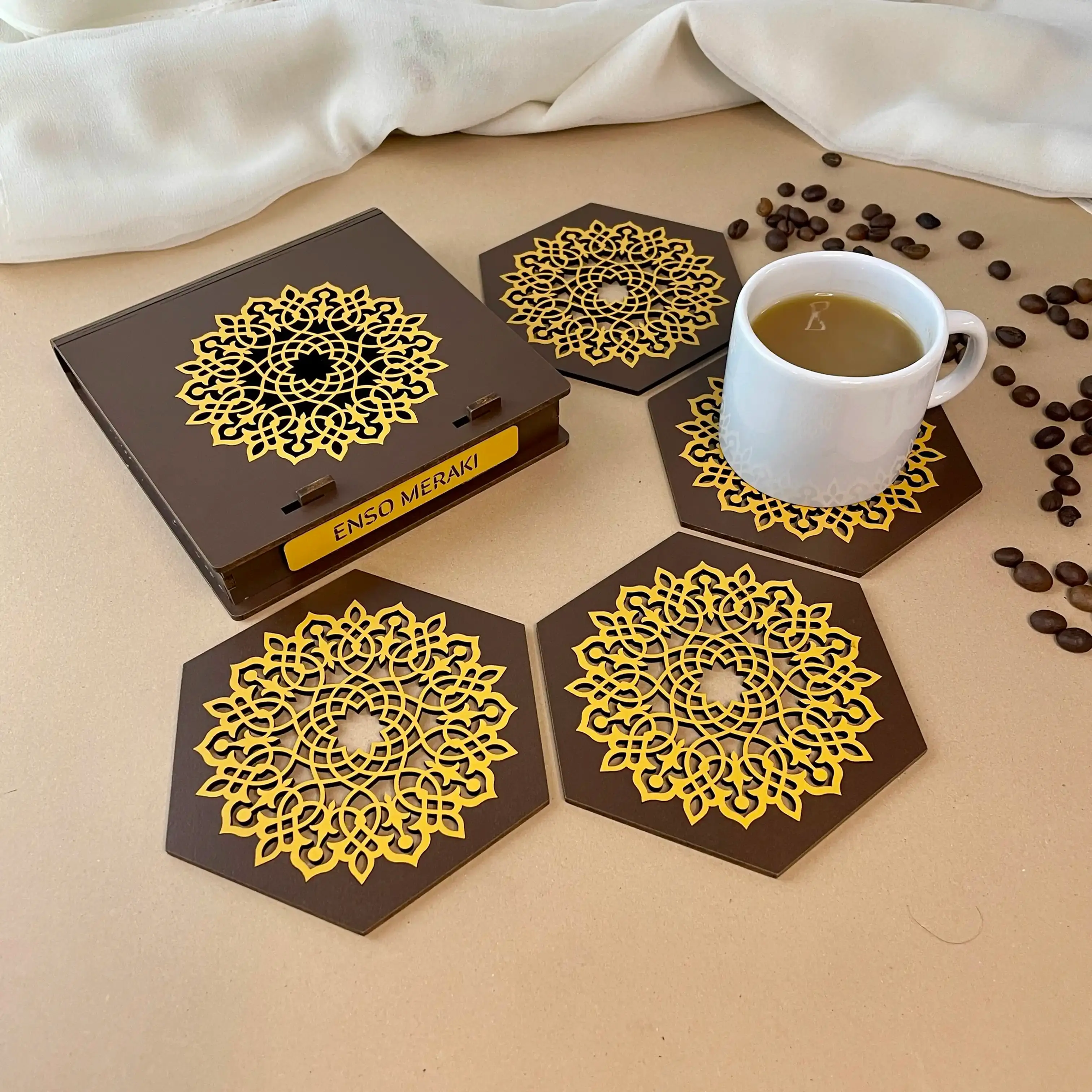 Aurelia laser cut coaster set with designer box in brown and yellow with tea cup & coffee beans, angled lifestyle image