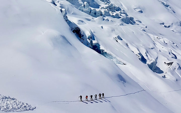 Skitourengänger laufen über einen eindrücklich aufgerissenen Gletscher