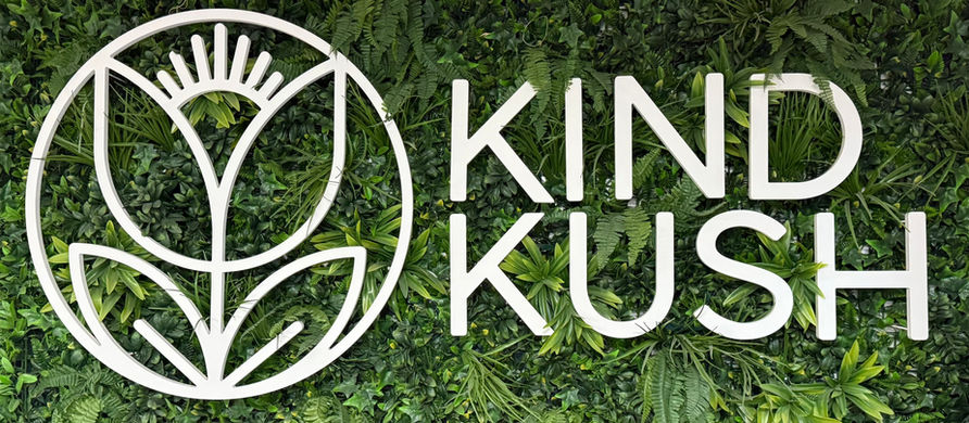 Kind Kush logo placed in a wall of green grass.