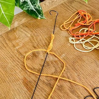 Réalisation d'un noeud plat en macramé.