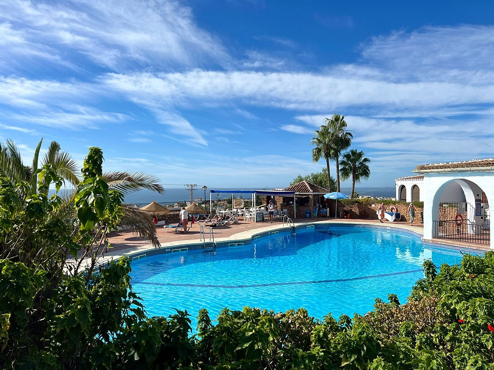 Amplia zona de piscina con dos grandes piscinas, una piscina infantil y un bar junto a la piscina en Capistrano Village, Nerja, España.