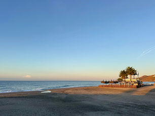 Auringonnousu Nerjan Playa el Playazolla, tyyni meri ja kullanvärinen taivas