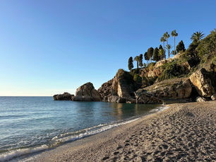 Sunny winter day at Playa Carabeillo in Nerja, clear sky, calm sea and golden sand