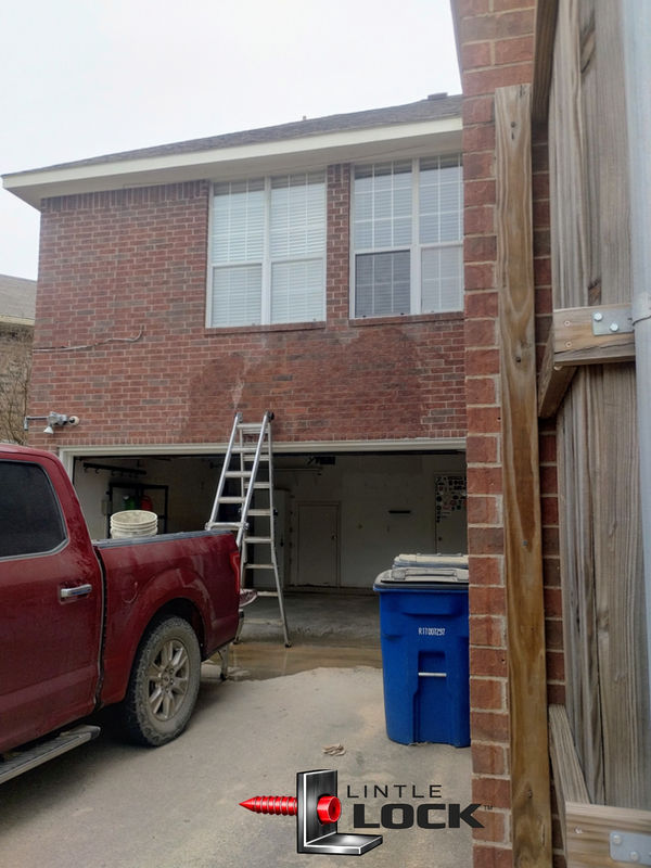 Before repair — cracked mortar and sagging lintel above garage door