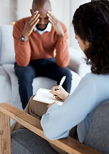 woman-psychologist-writing-black-man-therapy-with-mental-health-stress-headache-depressed-