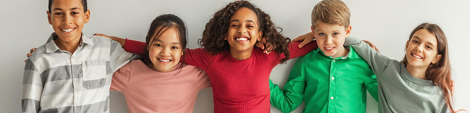 cheerful-multiethnic-children-hugging-posing-smiling-camera-indoors.jpg