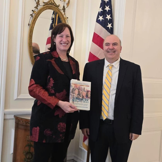 Alejandro entregando su libro a Heidi Fulton, embajadora de Estados Unidos en Uruguay, en un encuentro diplomático para fortalecer la cooperación bilateral.