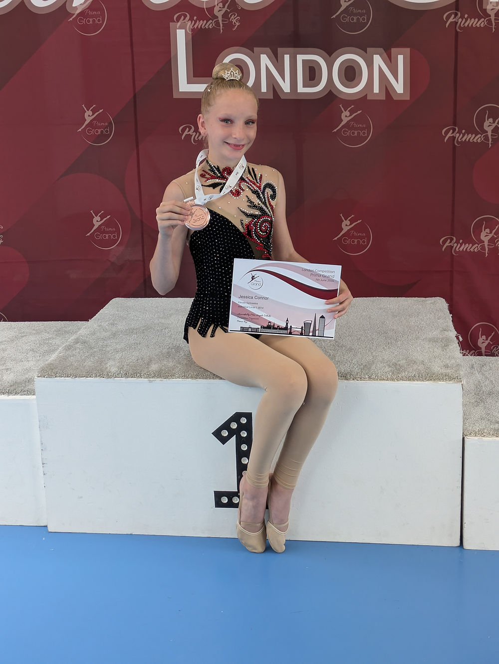 Gymnast on competition podium with medal