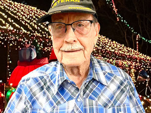 Richard Wilkinson standing in front of his house decorated with many Christmas lights