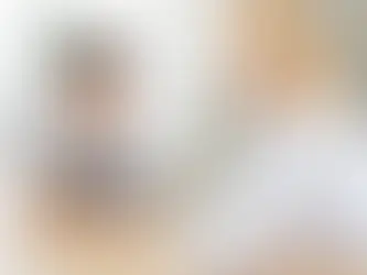 Young boy speaking with speech therapist during voice evaluation at clinic, seated at table in bright, calm office setting today.